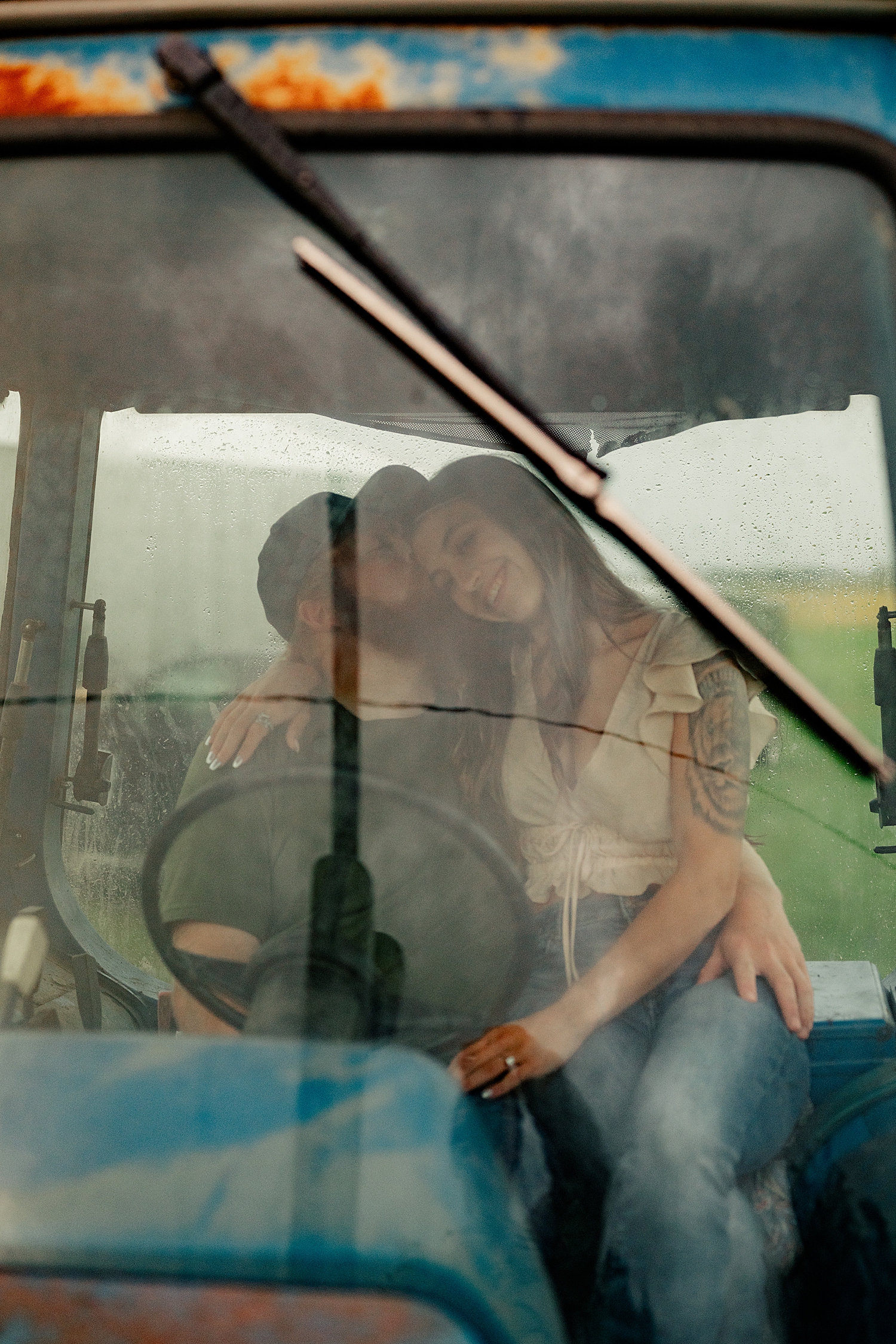 couple snuggles up in tractor by Minnesota wedding photographer