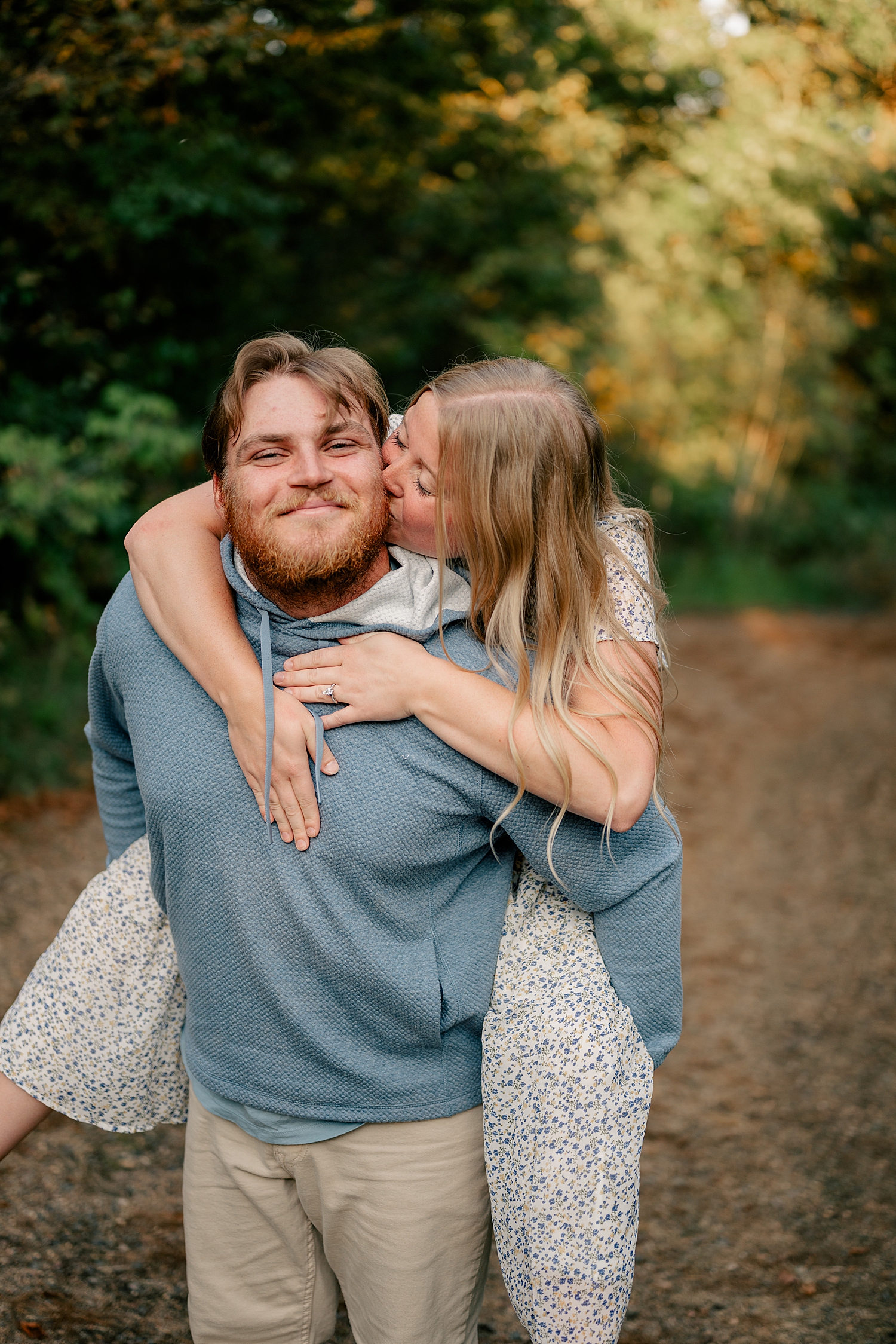 blonde woman jumps on man's back outside by Rule Creative Co