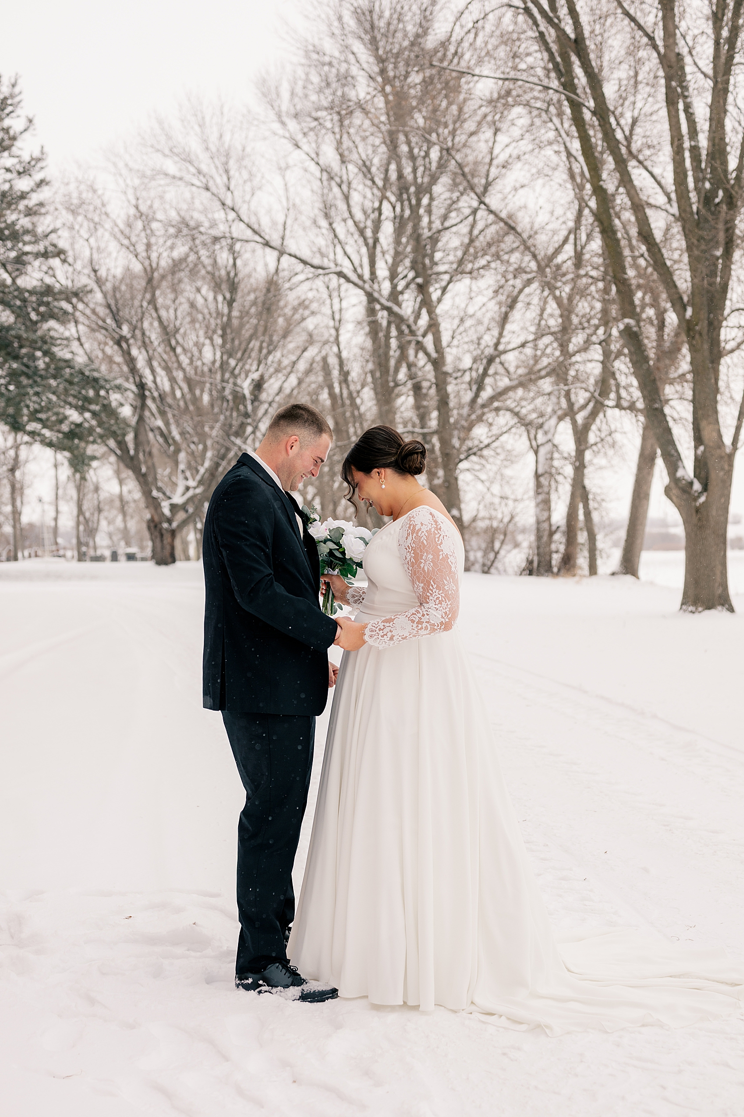 couple look at grasped hands together by Midwest photographer