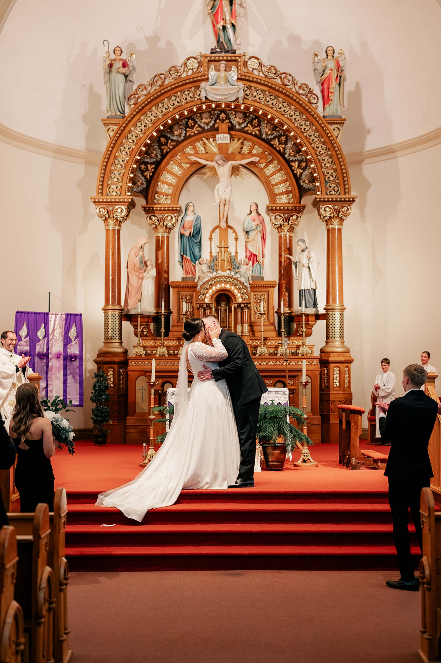 newlyweds share their first kiss at ornate alter by Midwest photographer