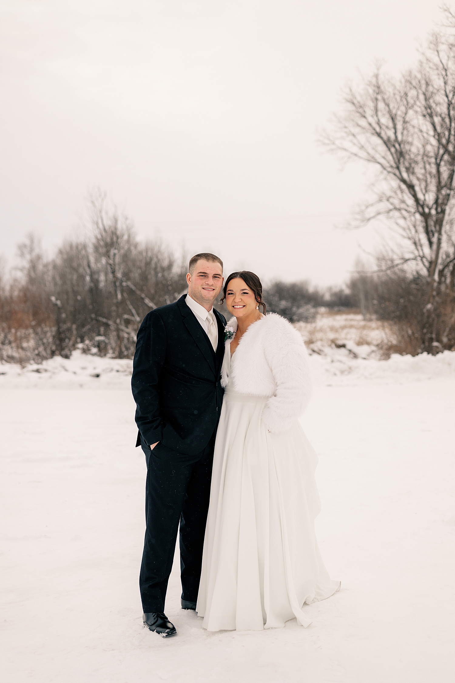 newlyweds stand together in the snow by Rule Creative Co