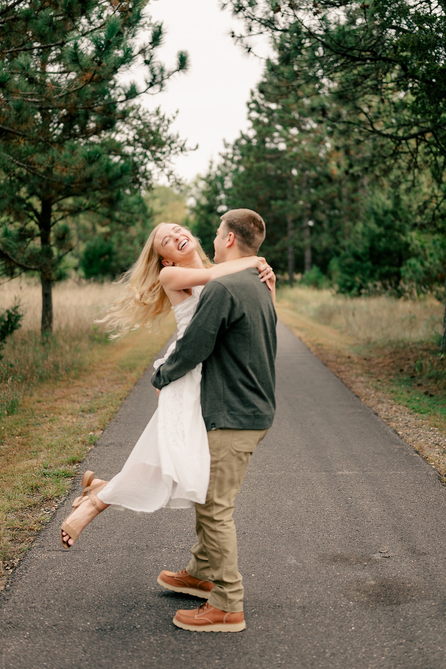blonde laughs in white dress as she's spun around by Rule Creative Co
