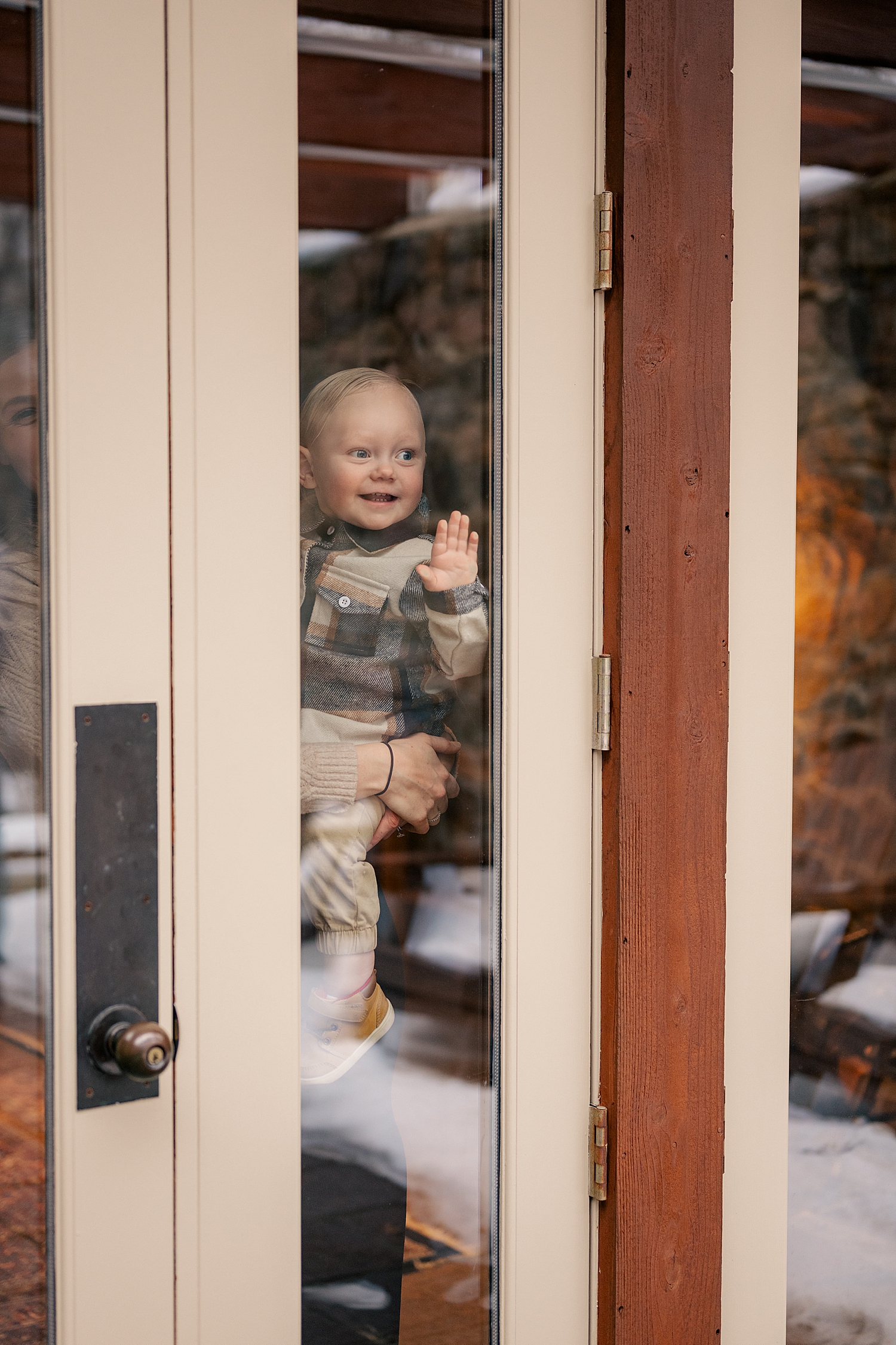 little boy looks through glass door at his grandma and gradpa who learned how to keep your elopement personal