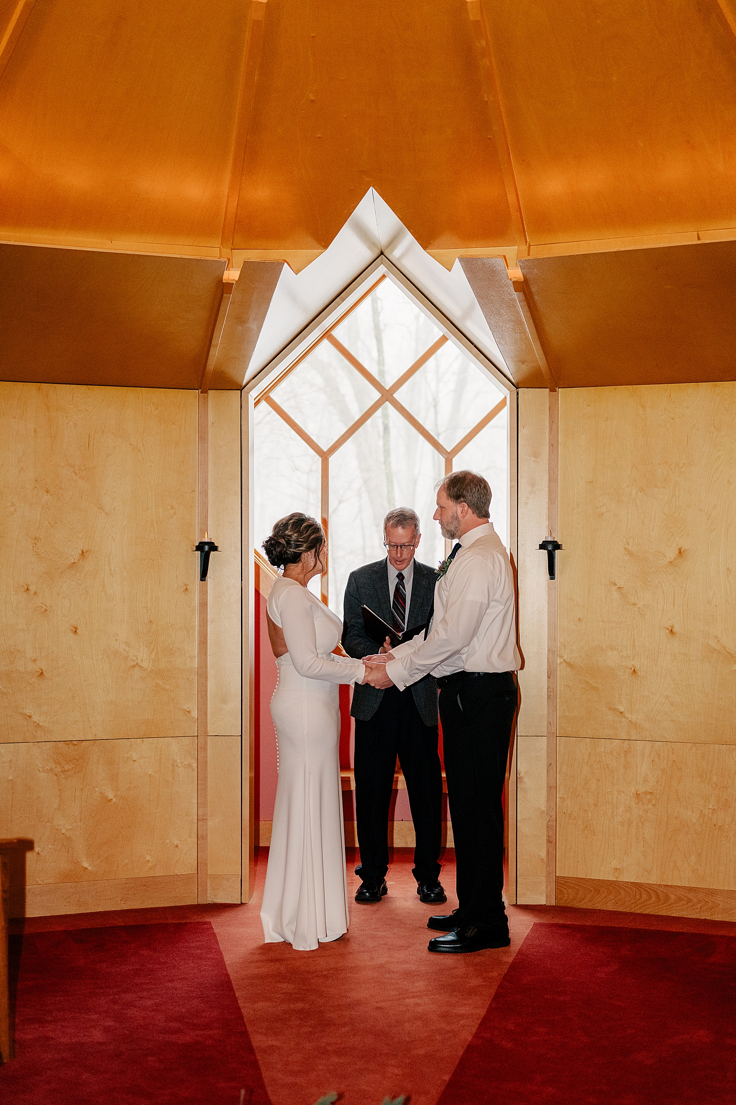 bride and groom stand at church window to say I Do after learning how to keep your elopement personal