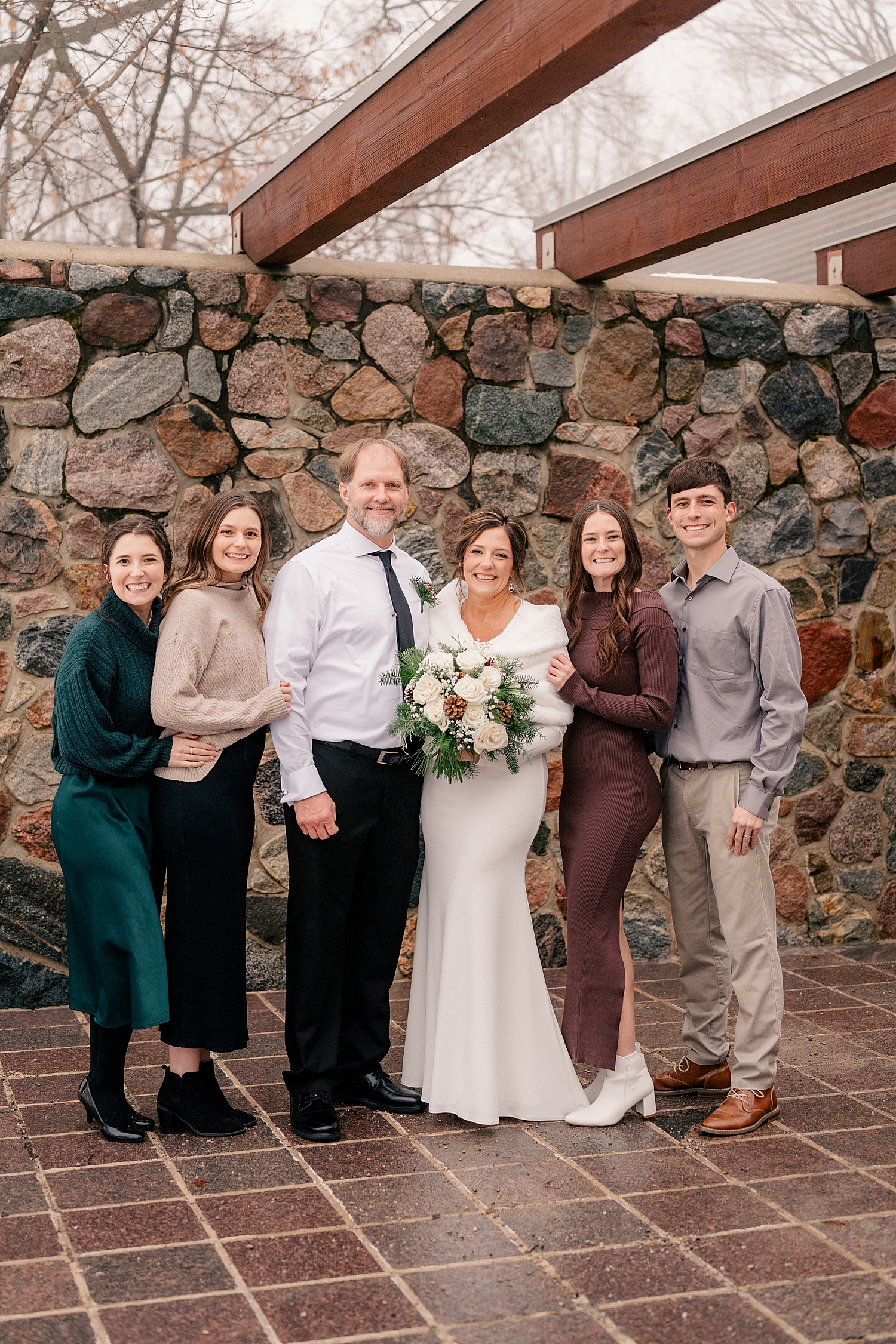 family gathers around newlyweds on outdoor patio by Rule Creative Co