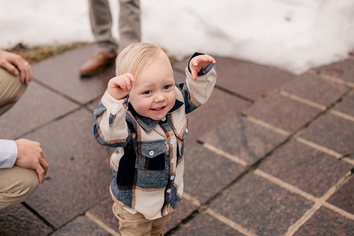 tiny toddler reaches up for mom while smiling by Minnesota wedding photographer