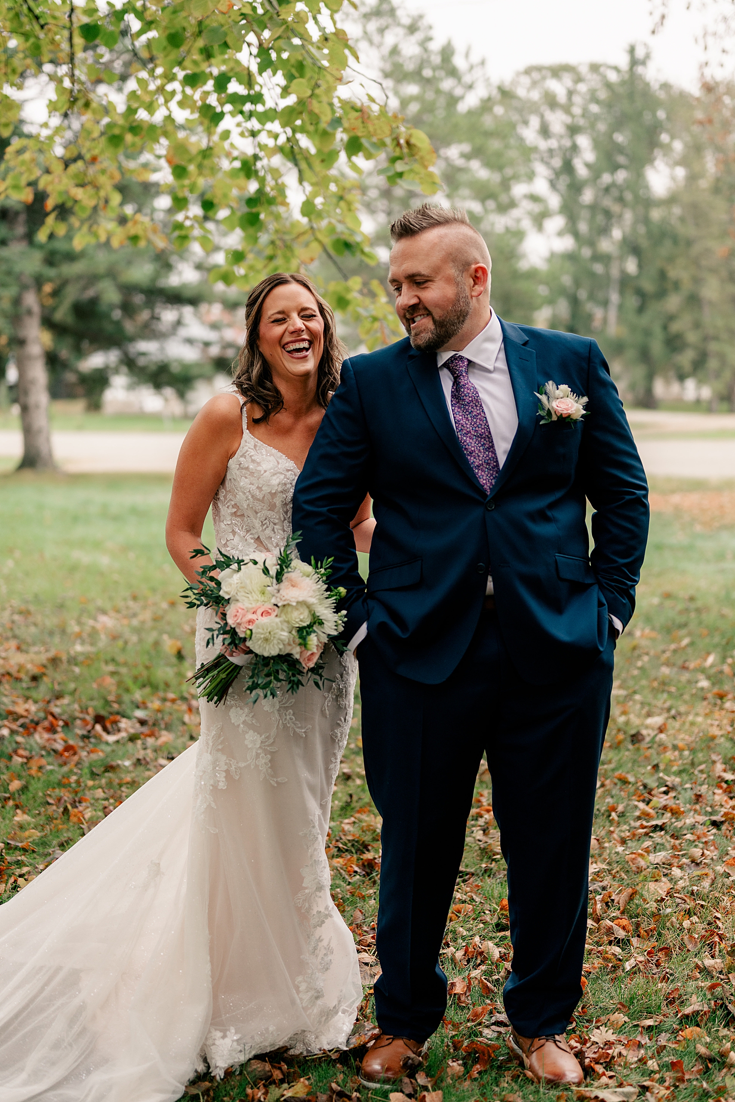 husband and wife laugh together in lawn by Rule Creative Co