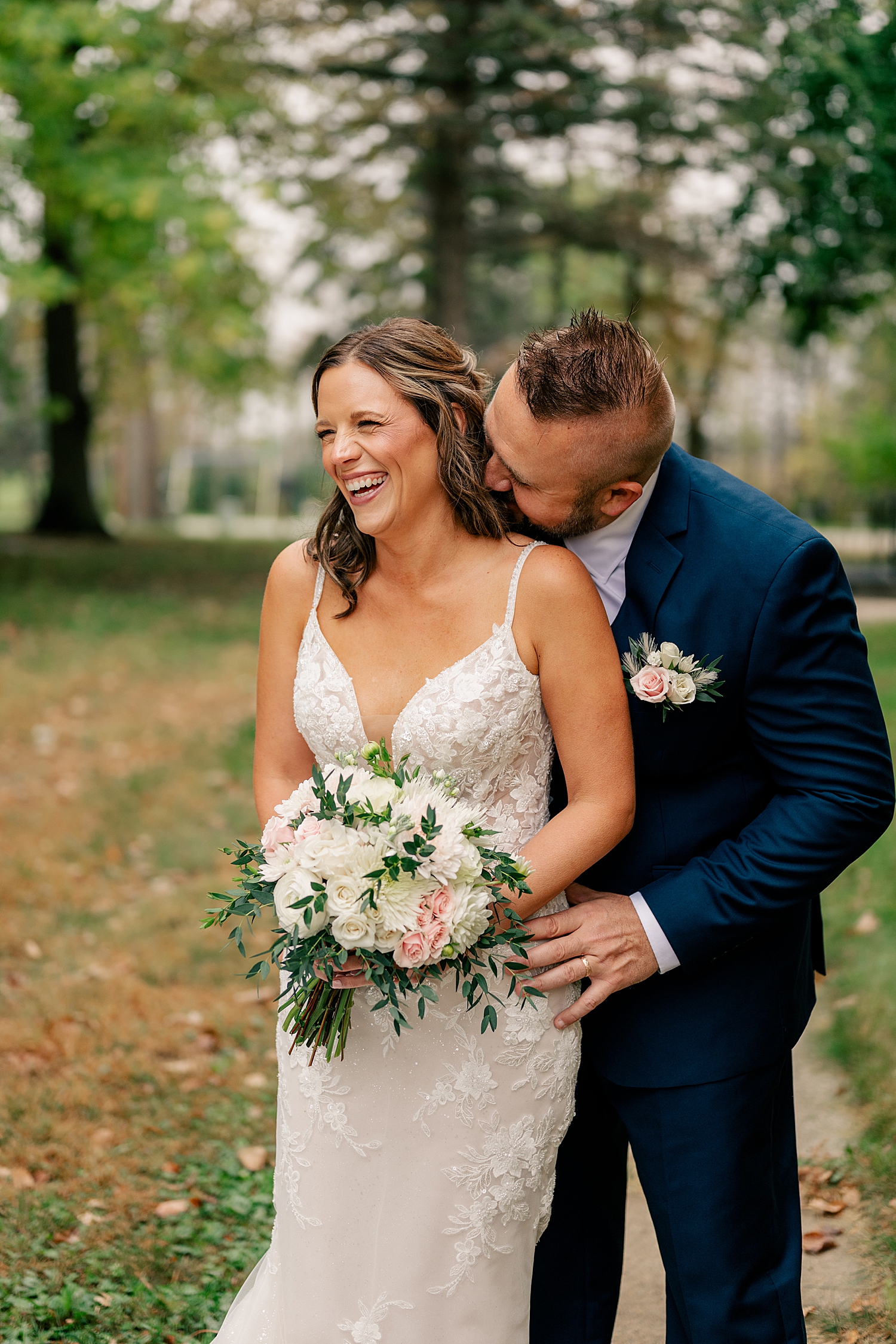 man kisses woman's neck while she giggles outside by Rule Creative Co