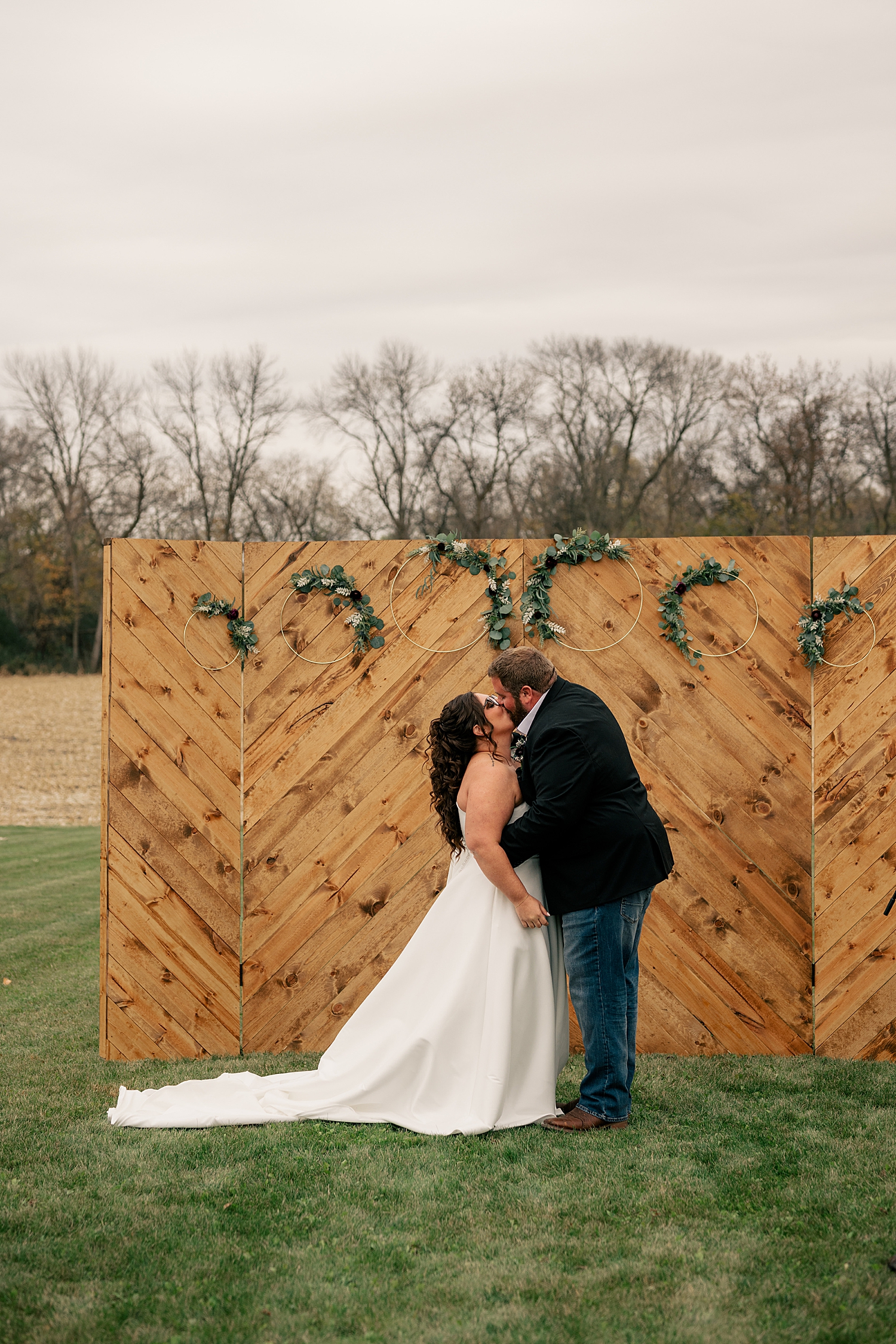 husband and wife share a kiss in front of custom alter by Rule Creative Co