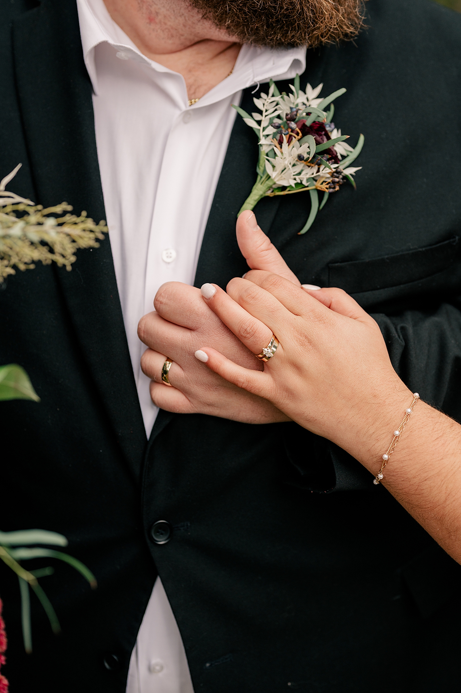 newlyweds hold hands to show off diamond ring at outdoor elopement at friend's home