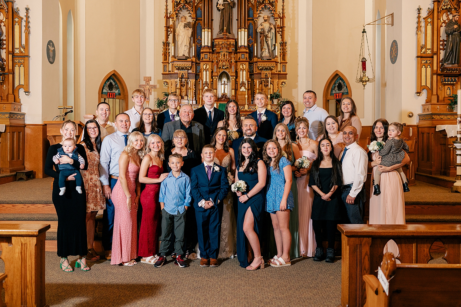 large group of people standing in catholic church by Minnesota wedding photographer