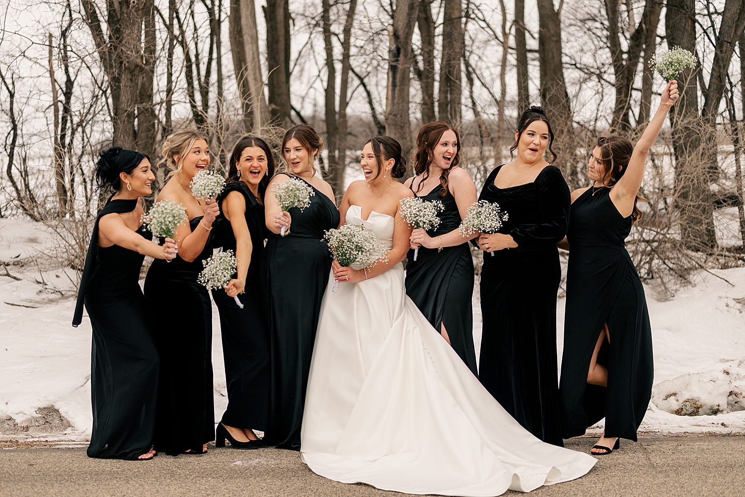 woman laughs with her bridesmaids who are wearing black dresses by Rule Creative Co