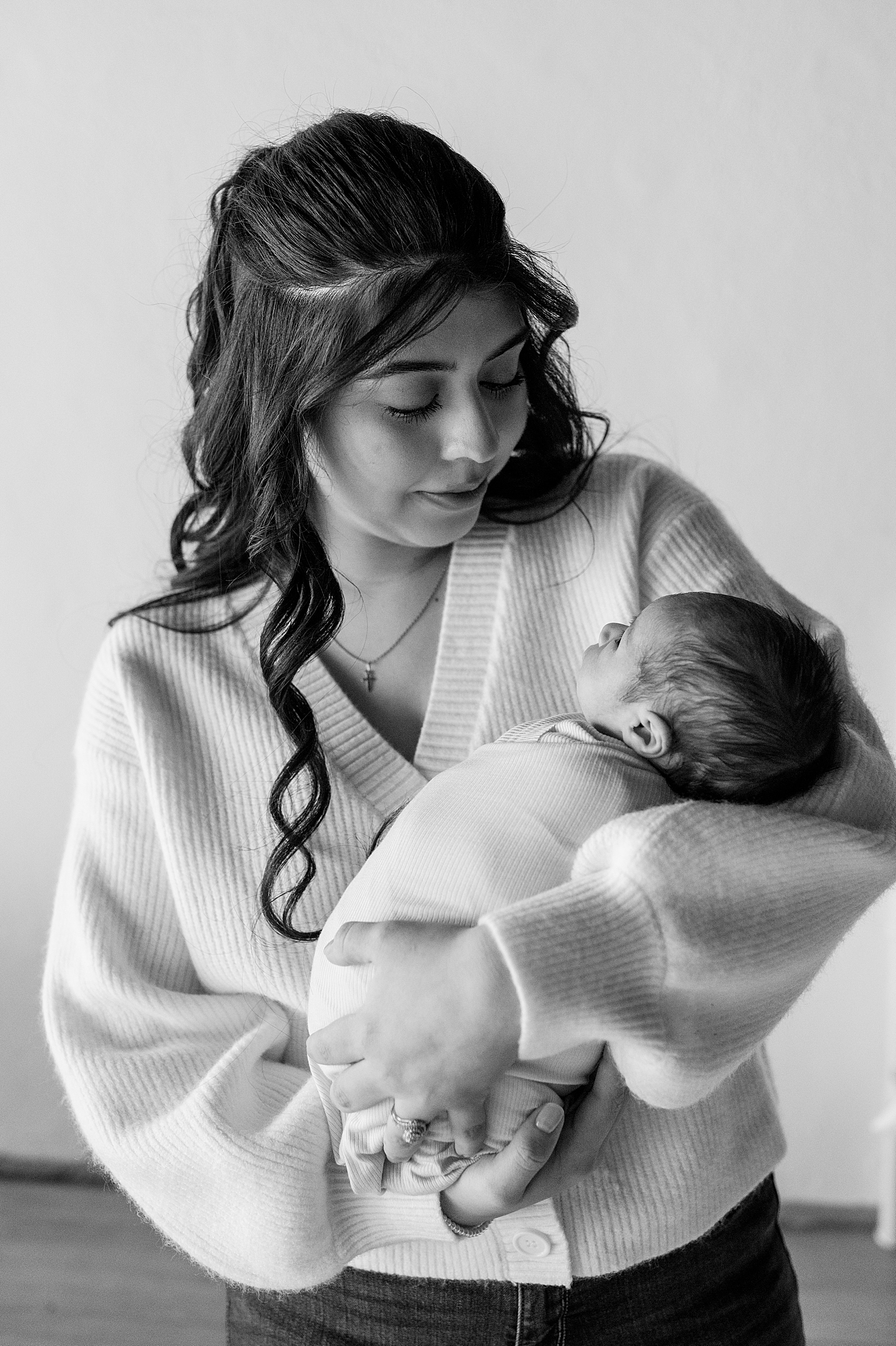 brunette mother holds infant son in her arms by Minnesota family photographer