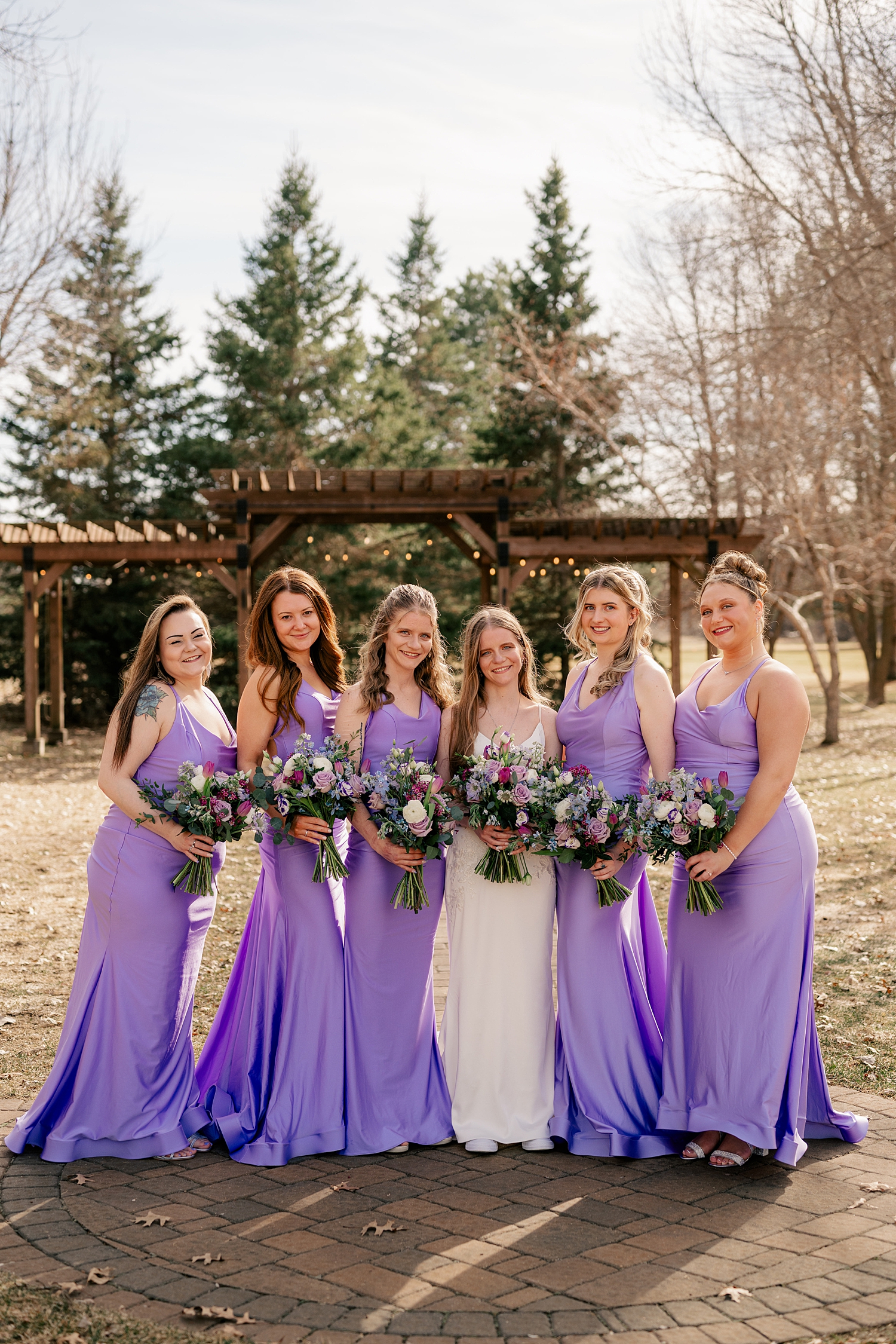 bridesmaids in long purple dresses next to bride by Rule Creative Co