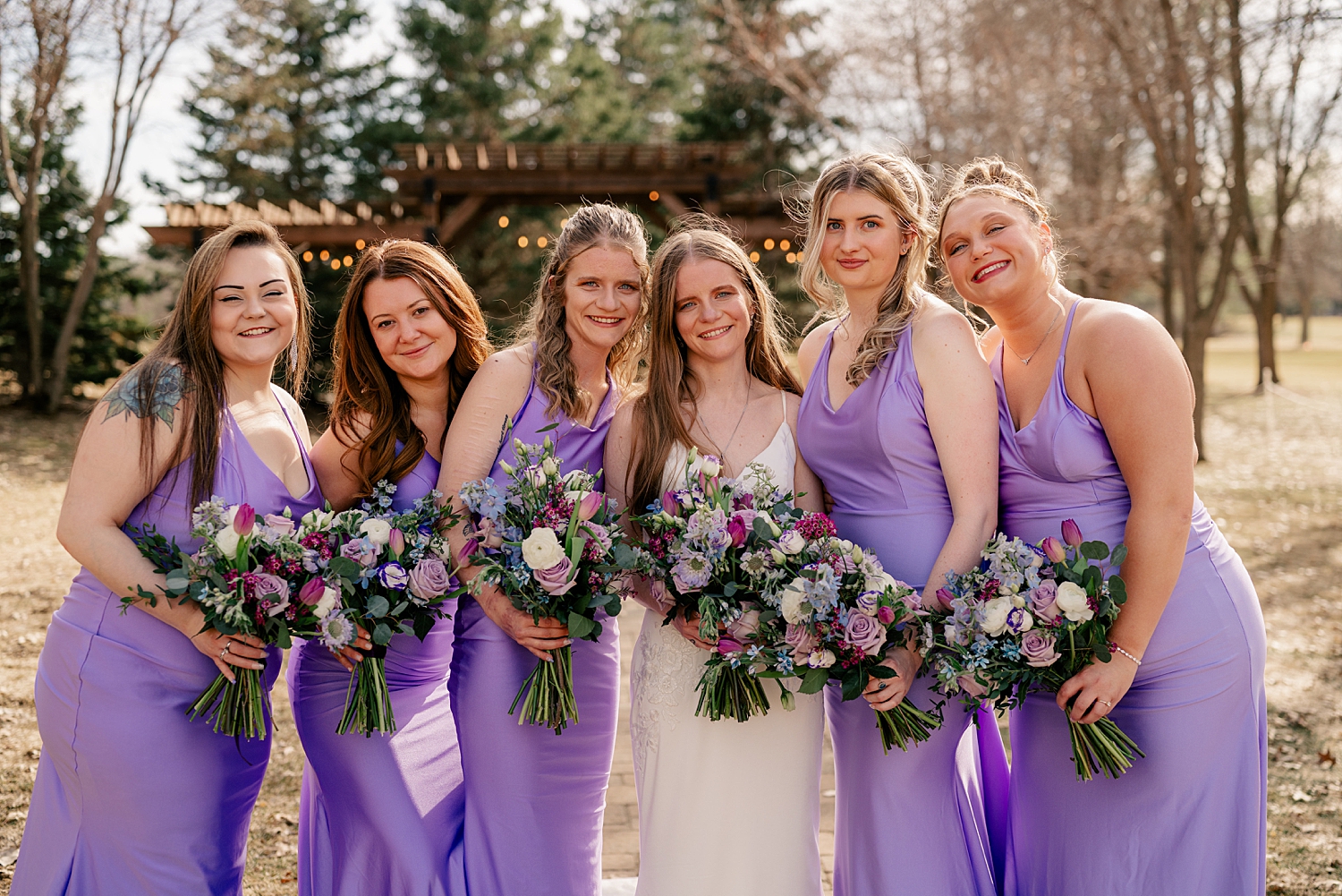 bride surrounded by her bridesmaids in bright purple for Minnesota Spring Wedding