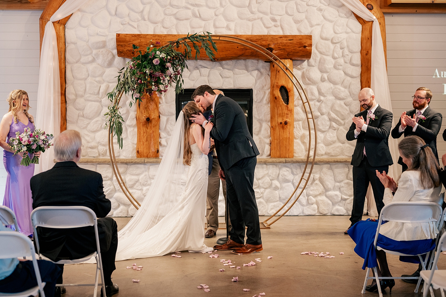 newlyweds share first kiss under circle arch by Rule Creative Co