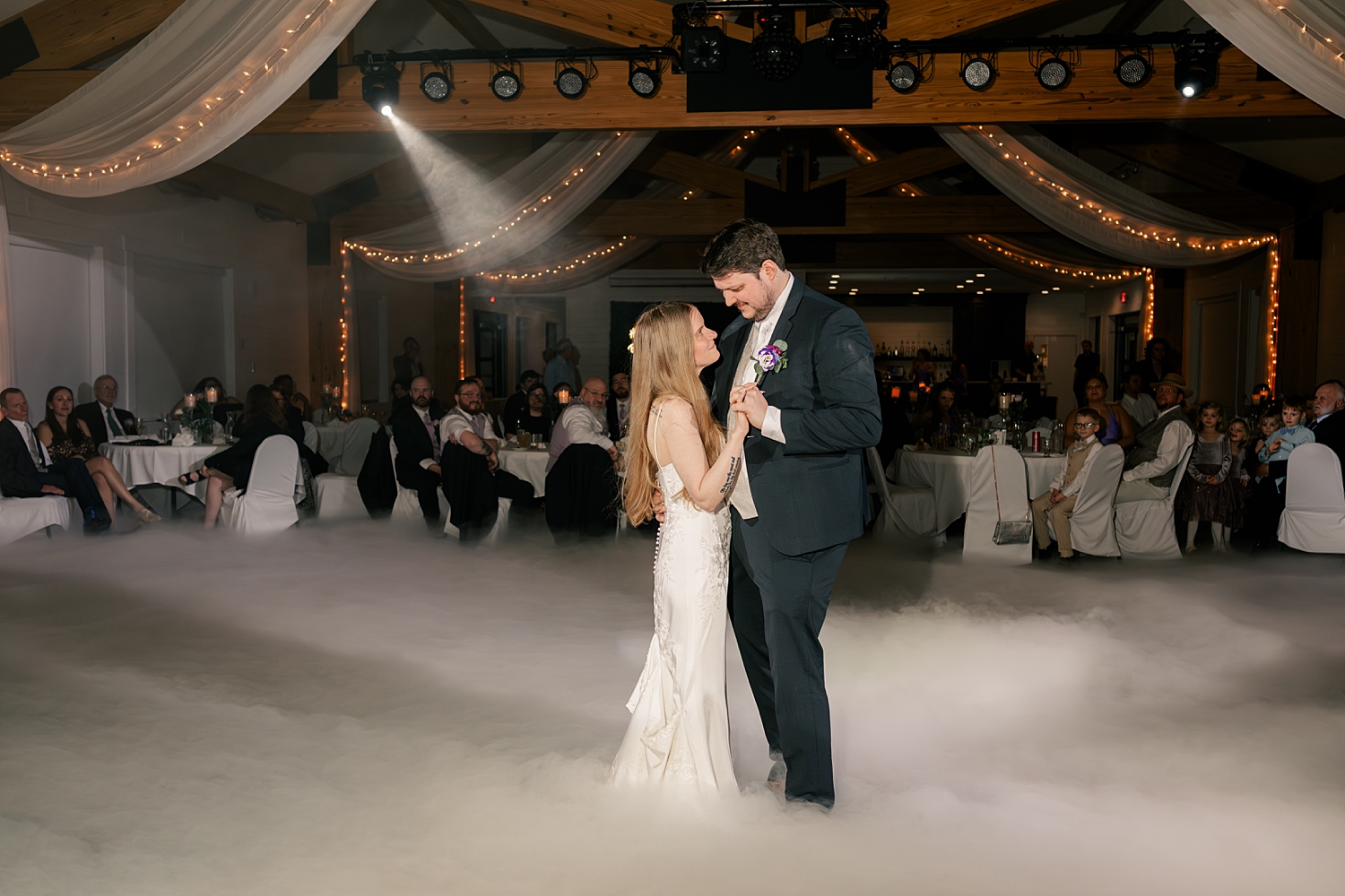 man dances with his new wife on foggy dance floor by Rule Creative Co