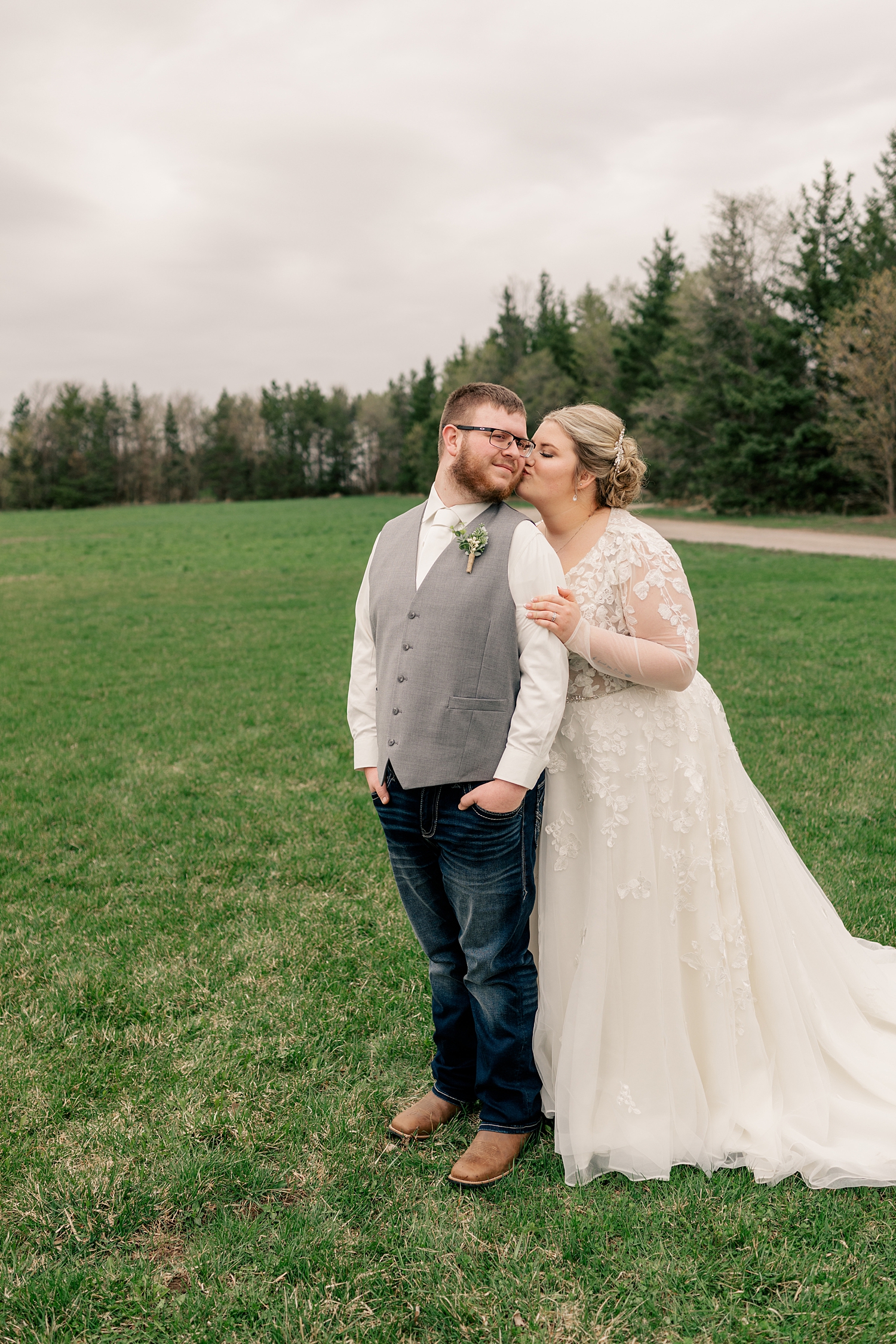 woman leans in to kiss her groom in field by Minnesota elopement photographer