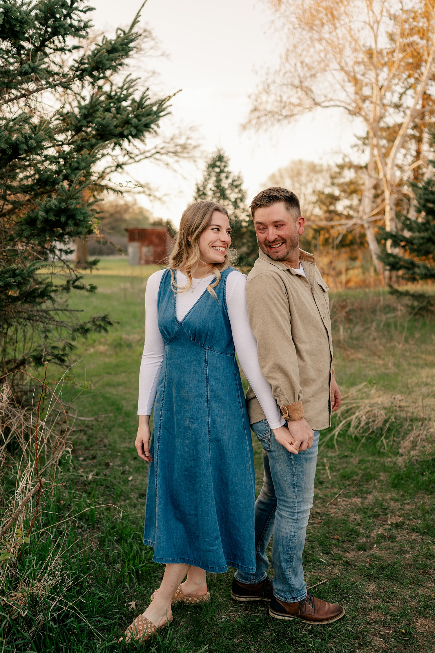 engaged couple stand back to back at Bend in The River Park for summer engagement photos