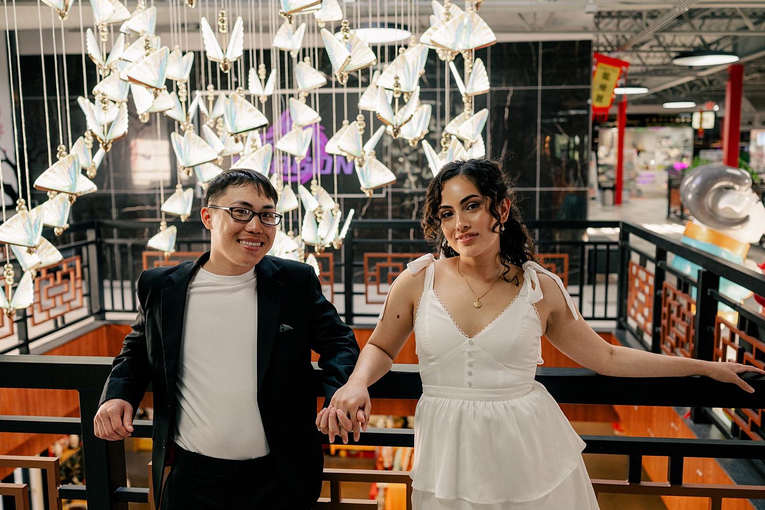 couples stands next to display at Asia Mall showing a unique engagement session location