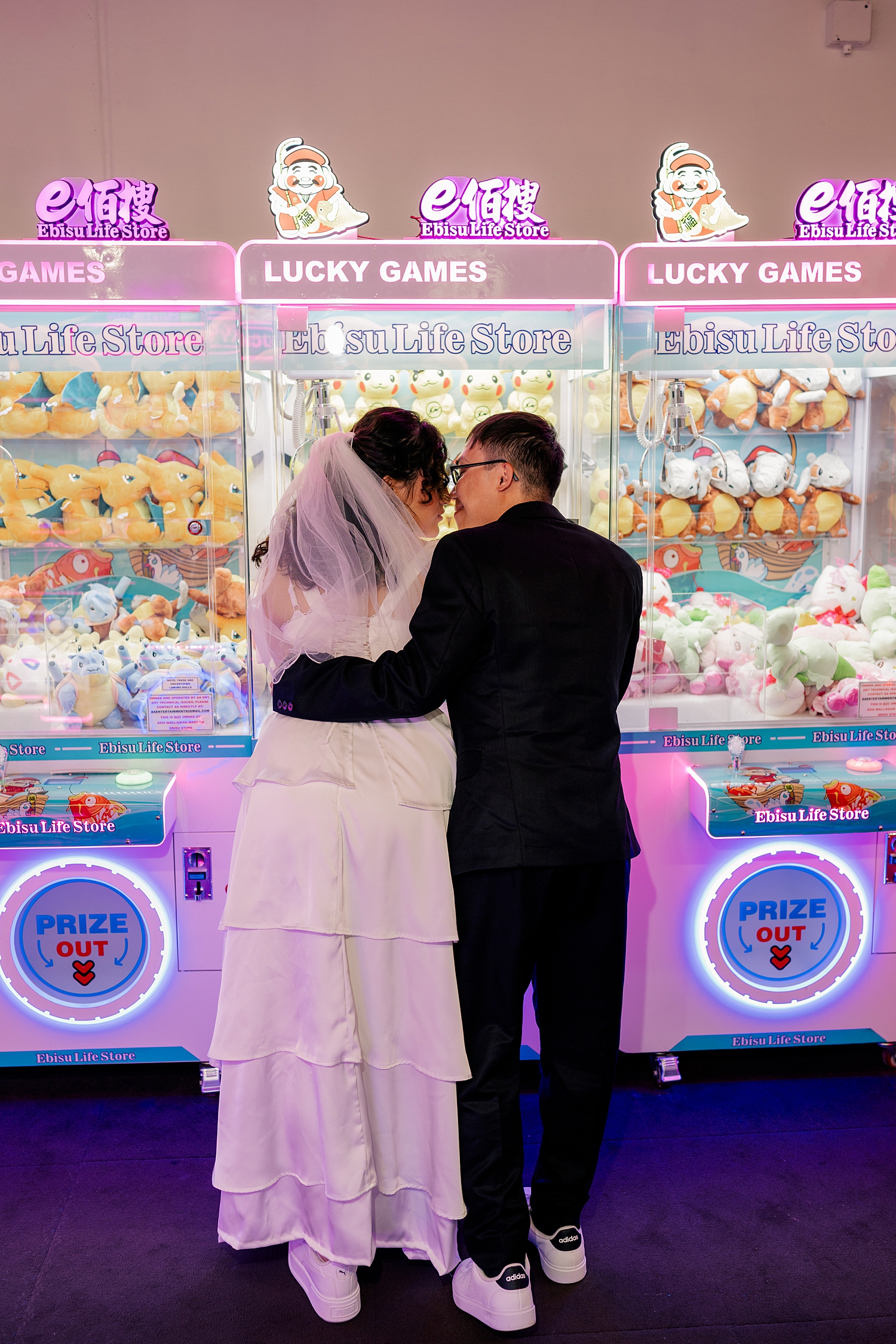 man looks at his bride over prize machine by Minnesota wedding photographer