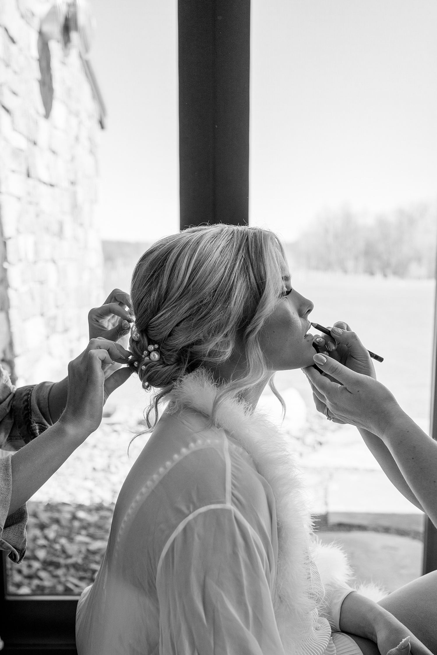 blonde bride gets lipstick done by Minnesota wedding photographer