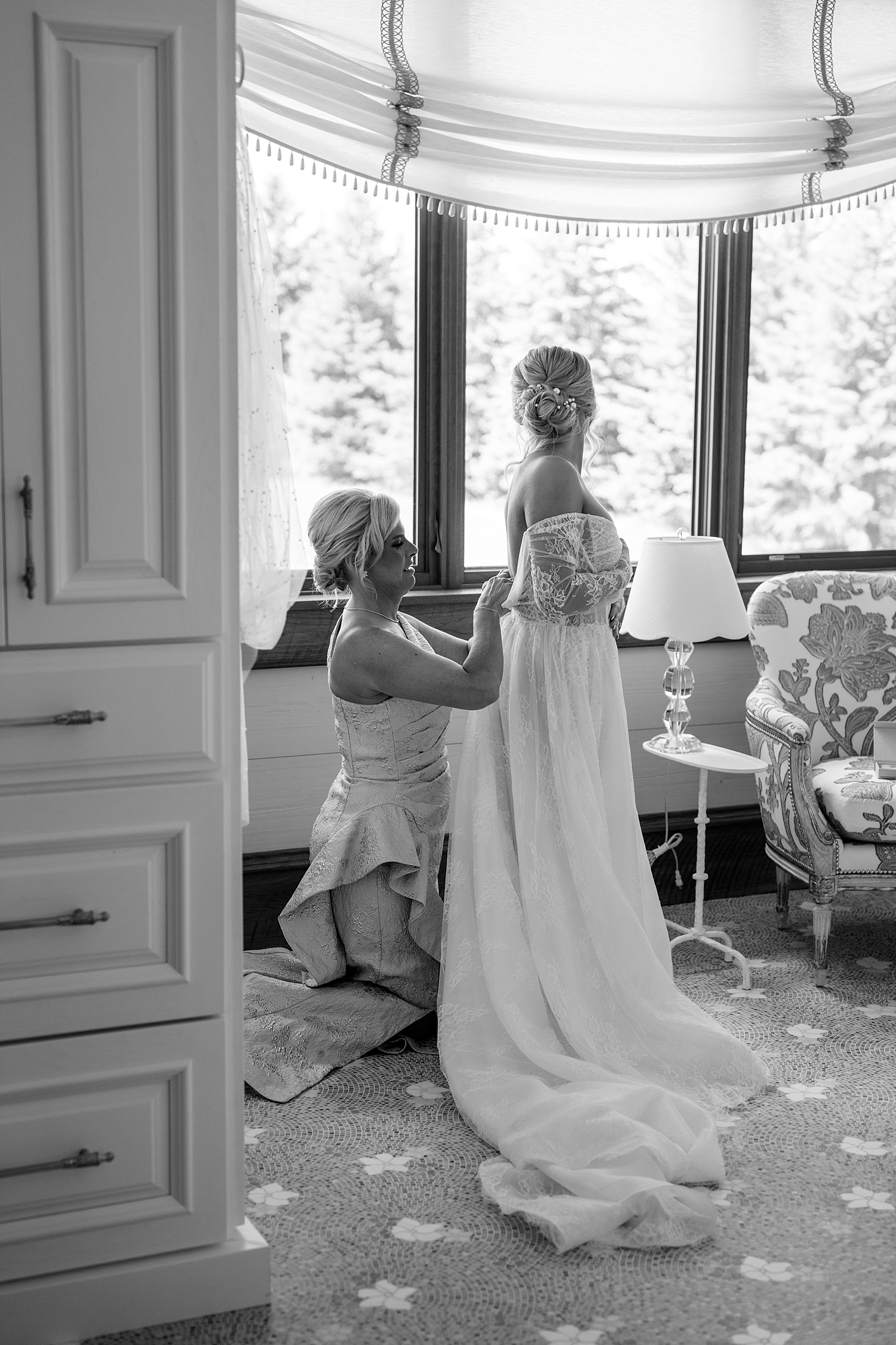woman in bridal gown gets zipped up by her mom by Rule Creative Co 
