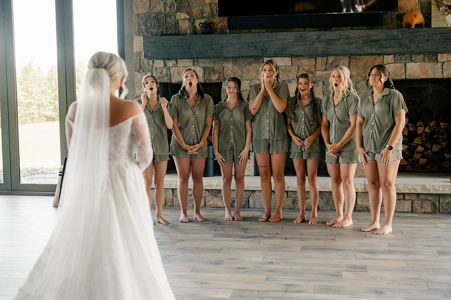 bridesmaids in green pajamas have a first look with bride at Stearns County Pioneer Club