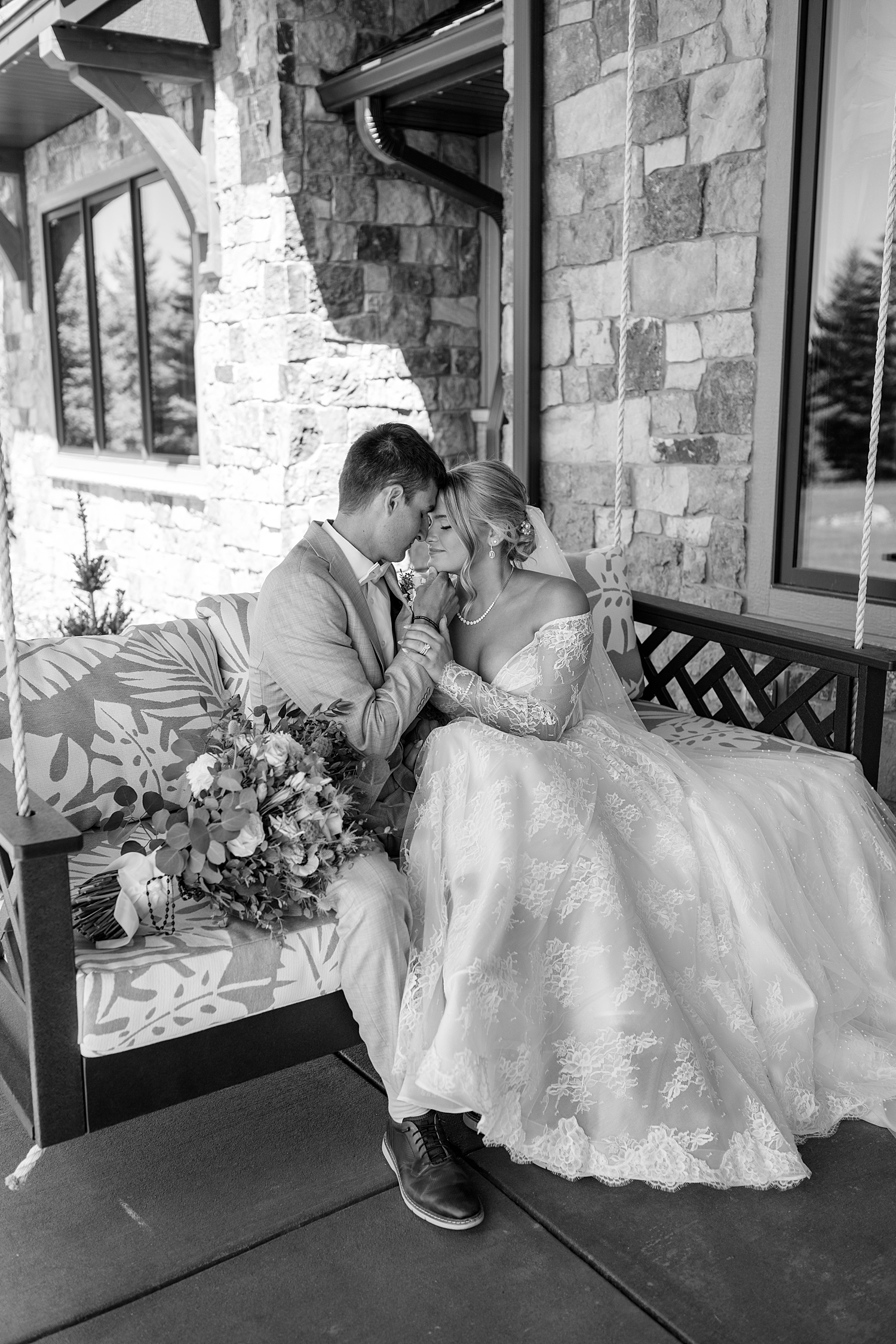 couple embraces on porch swing on their big day by Rule Creative Co 