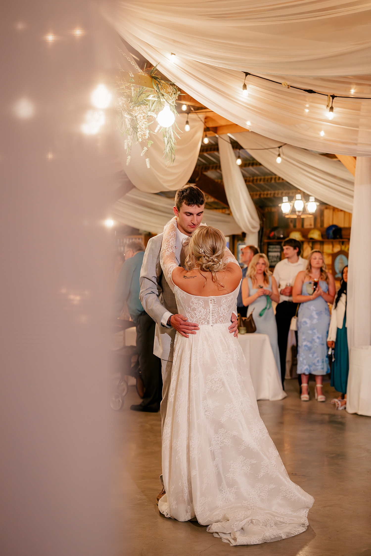 newlyweds share a first dance under twinkle lights by Minnesota wedding photographer