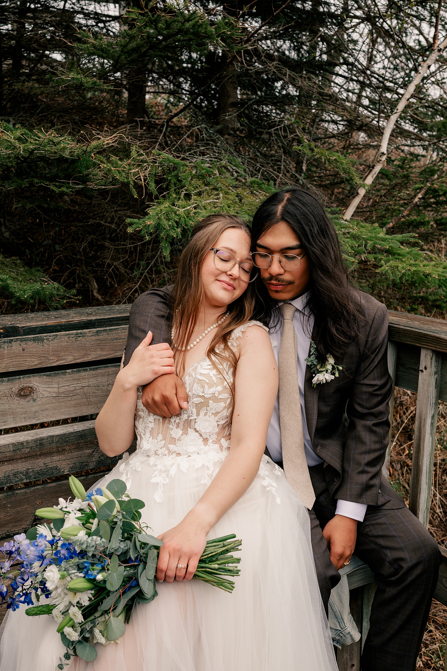 newlyweds snuggle on park bench by Rule Creative Co