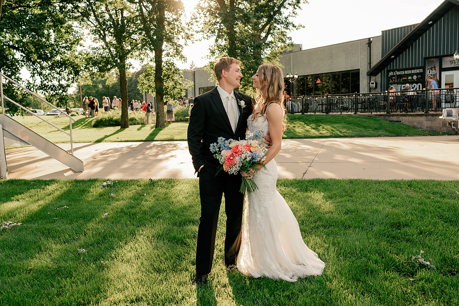 couple stand outside of their venue at golden hour by Minnesota wedding photographer 