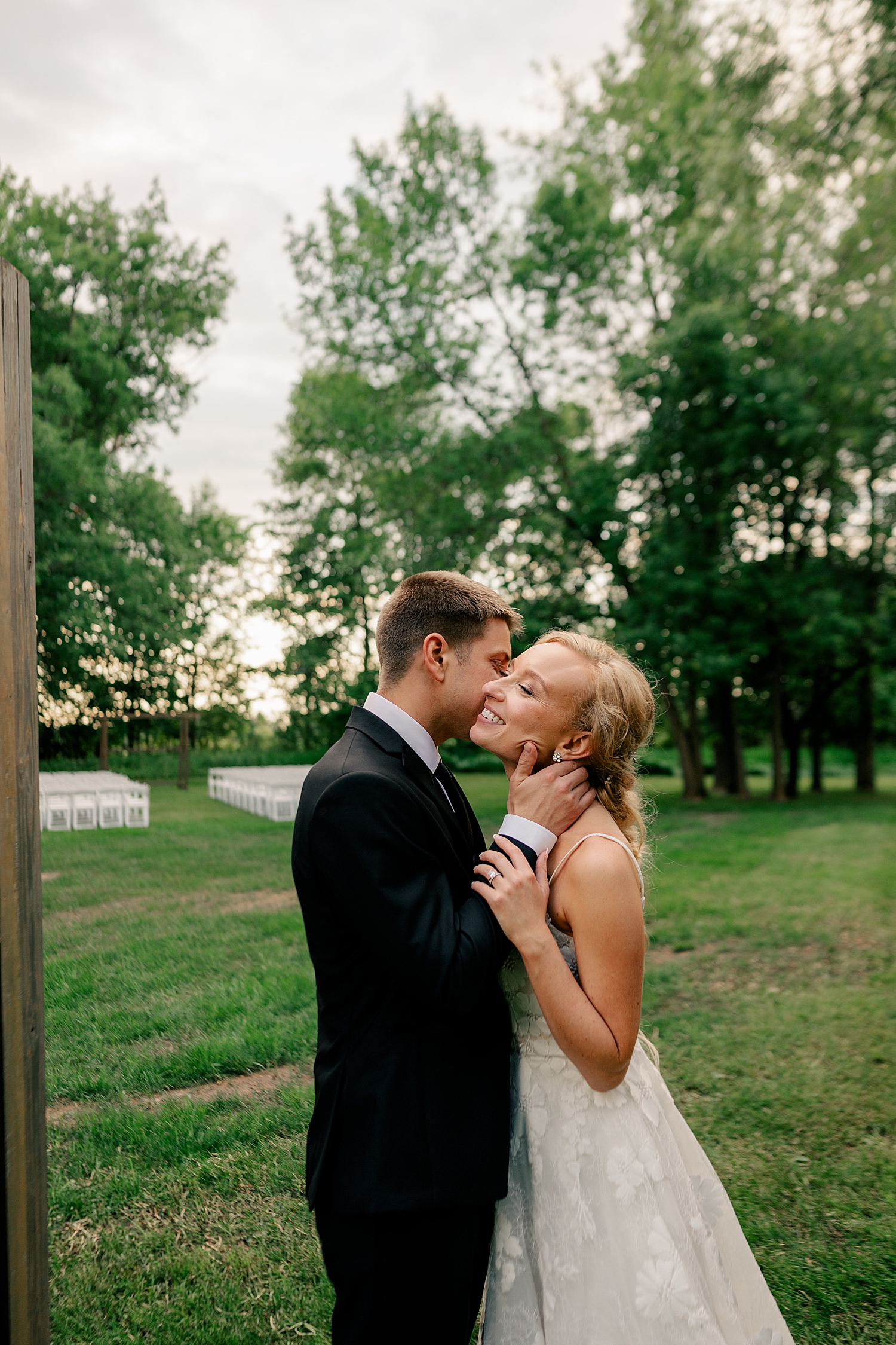 bride and groom share a kiss in front of open field by Rule Creative Co