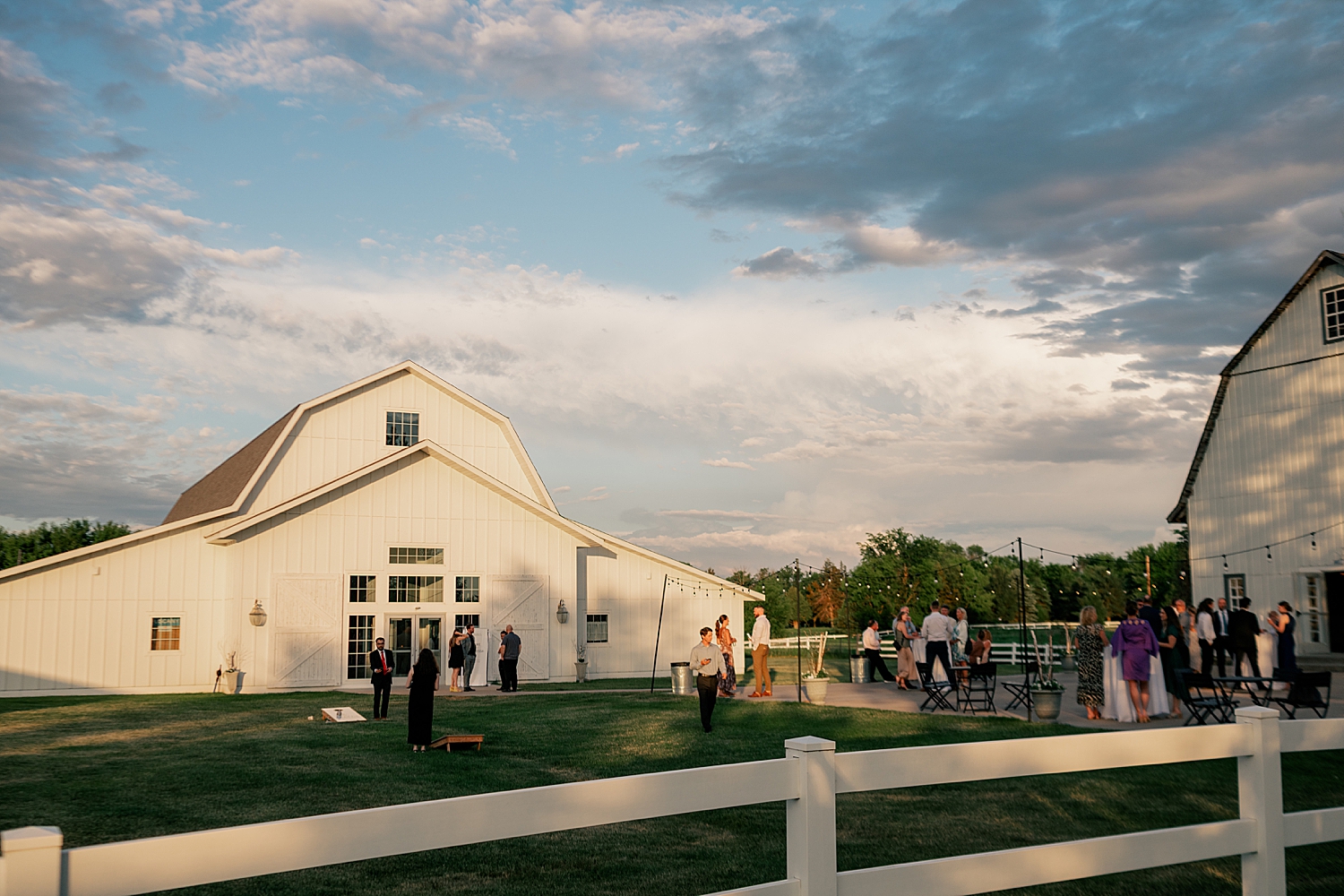 guests mingle outside barn at reception by Minnesota photographer