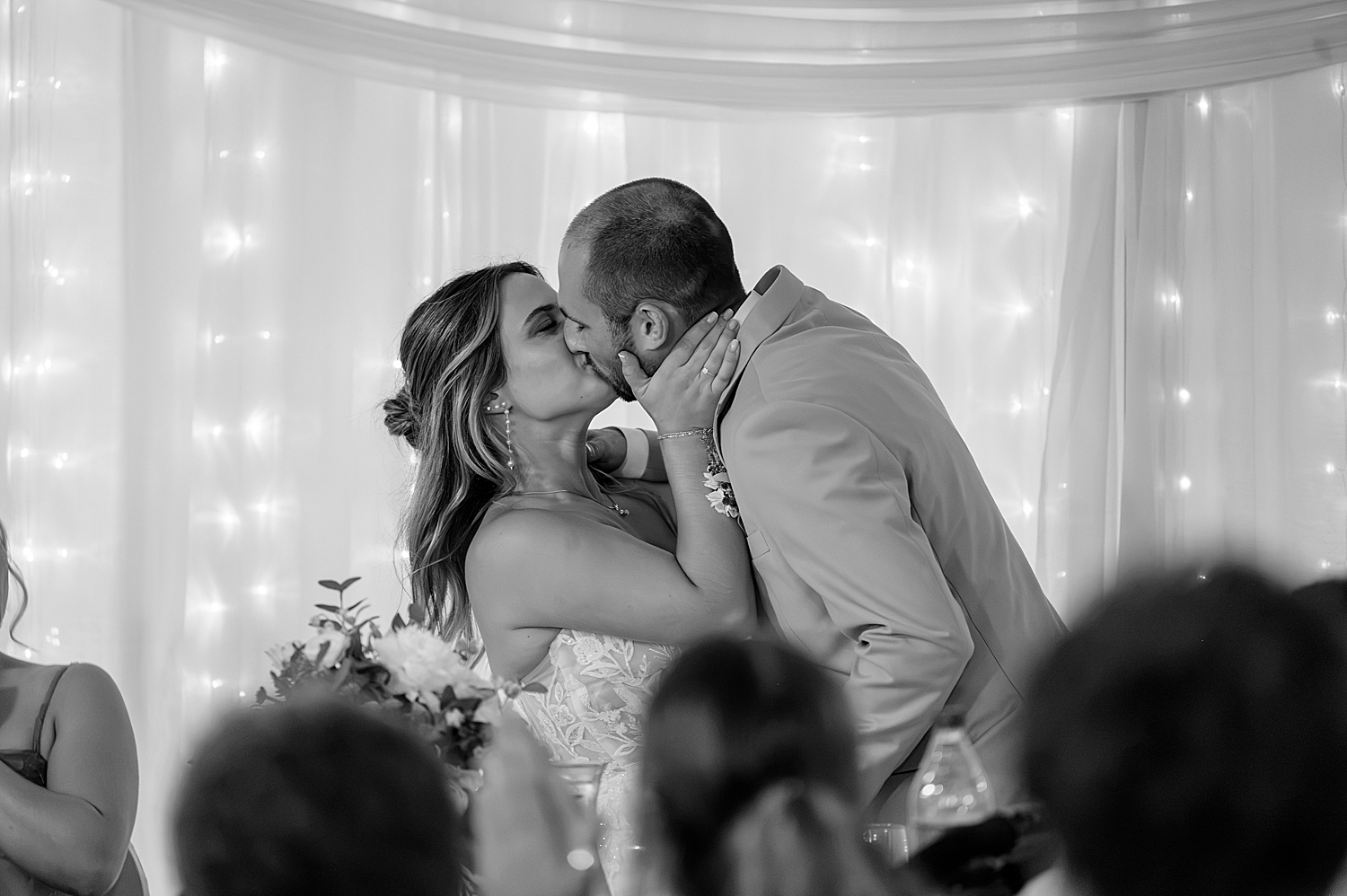 bride and groom share a passionate kiss during dinner by Minnesota photographer